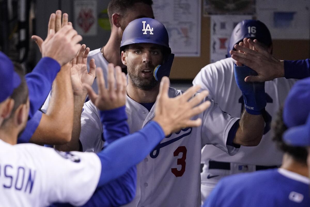 Los Angeles Dodgers' Chris Taylor is congratulated by teammates in the dugout after scoring on a double.