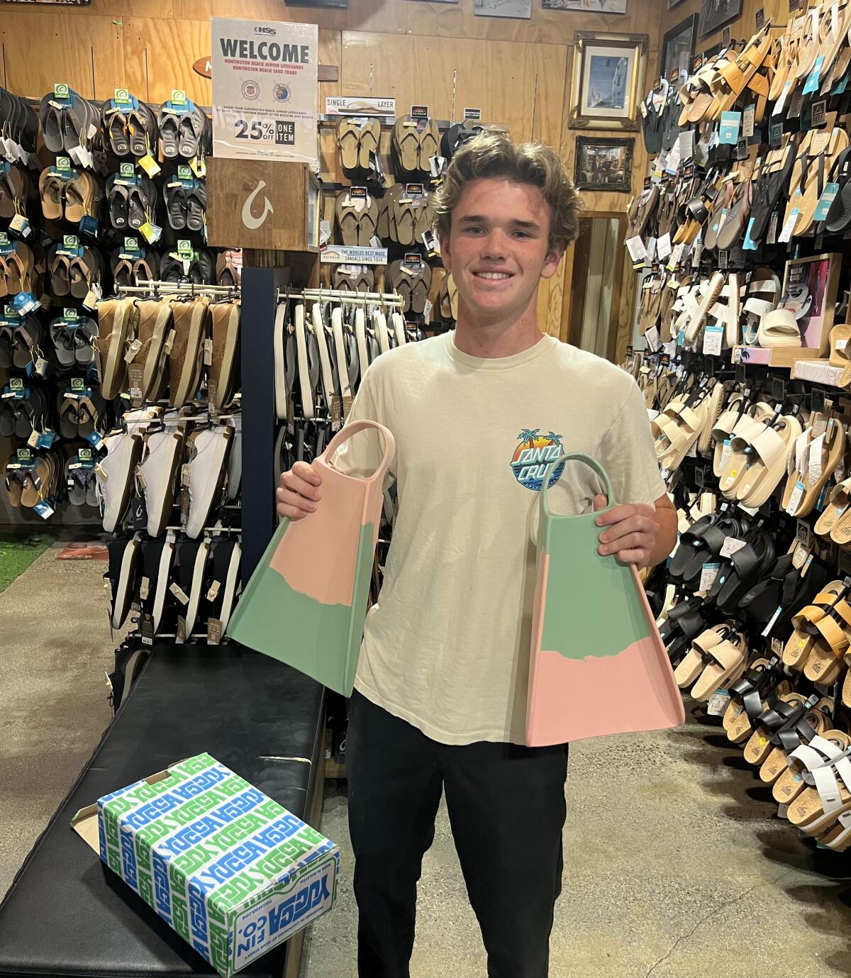 Huntington Beach Junior Lifeguard Ethan Brown shows off a pair of Yucca fins on Thursday at Huntington Surf & Sport.