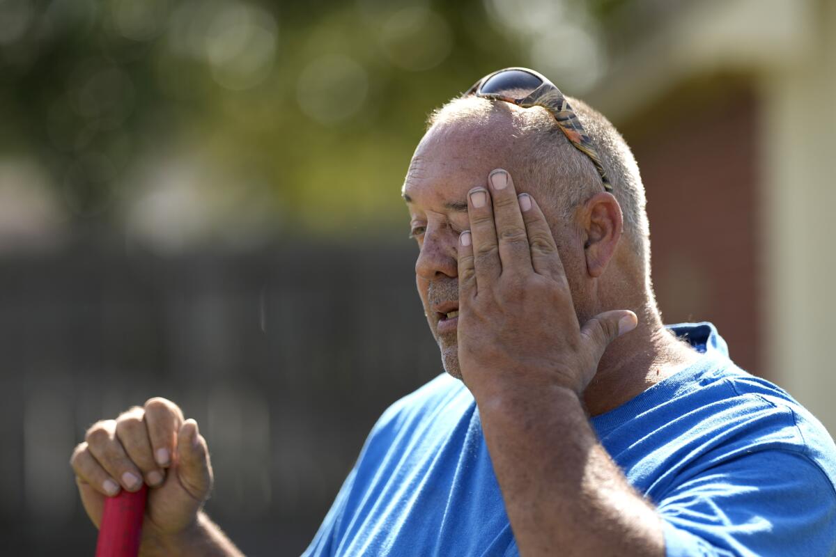 Robert Harris pauses to wipes his face while digging fence post holes on June 27, 2023, in Houston. 