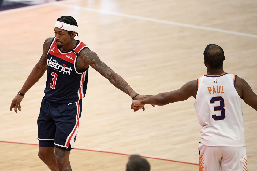 Washington Wizards guard Bradley Beal, left, and Phoenix Suns guard Chris Paul, right, tap hands during the second half of an NBA basketball game, Monday, Jan. 11, 2021, in Washington. (AP Photo/Nick Wass)