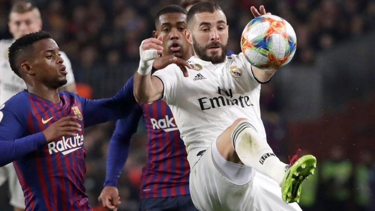 Real Madrid forward Karim Benzema controls the ball in front of Barcelona defender Nelson Semedo, left, during a Copa del Rey semifinal match on Wednesday.