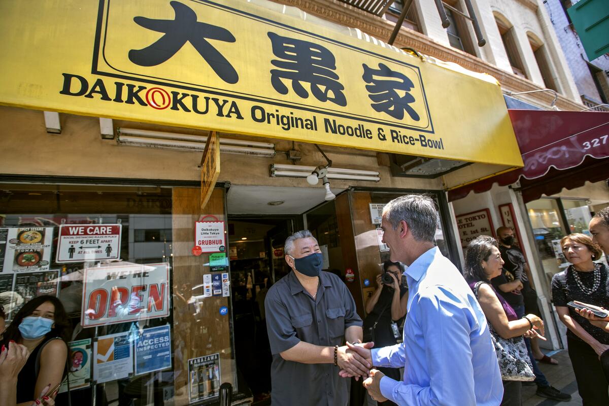 Los Angeles Mayor Eric Garcetti, right, greets Little Tokyo restaurant owner Takaaki Kohyama on Wednesday. 