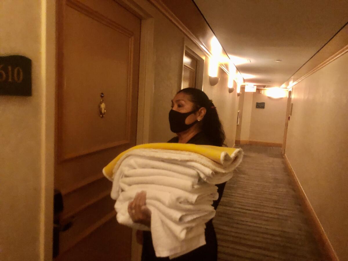 Beautiful Hotel Maid Holding Stack Of Clean Towels High-Res Stock