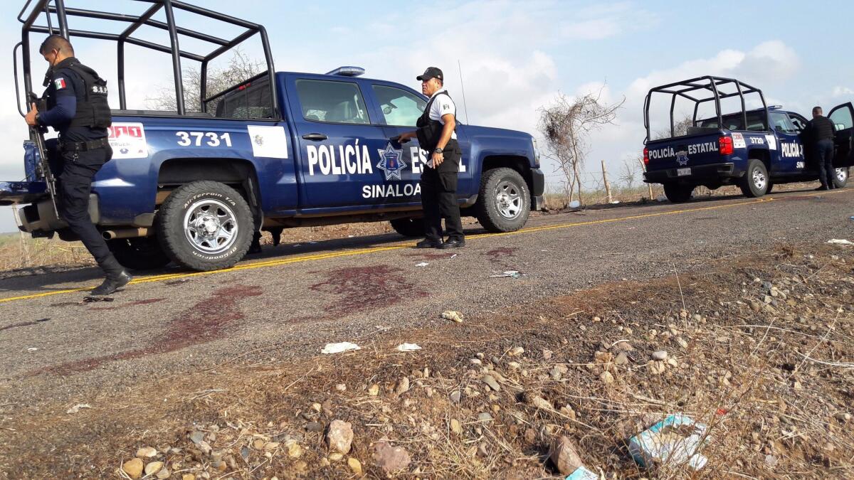 Mexican police guard a crime scene near the beach resort of Mazatlan, where 19 suspected drug cartel members died in clashes with police on July 1. On Wednesday, cartel violence claimed 26 more lives in neighboring Chihuahua state.