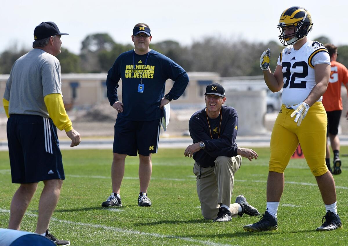 Michigan Coach Jim Harbaugh, center right, watches defensive coordinator Don Brown, left, work with Cheyenn Robertson in Bradenton, Fla, back in February.