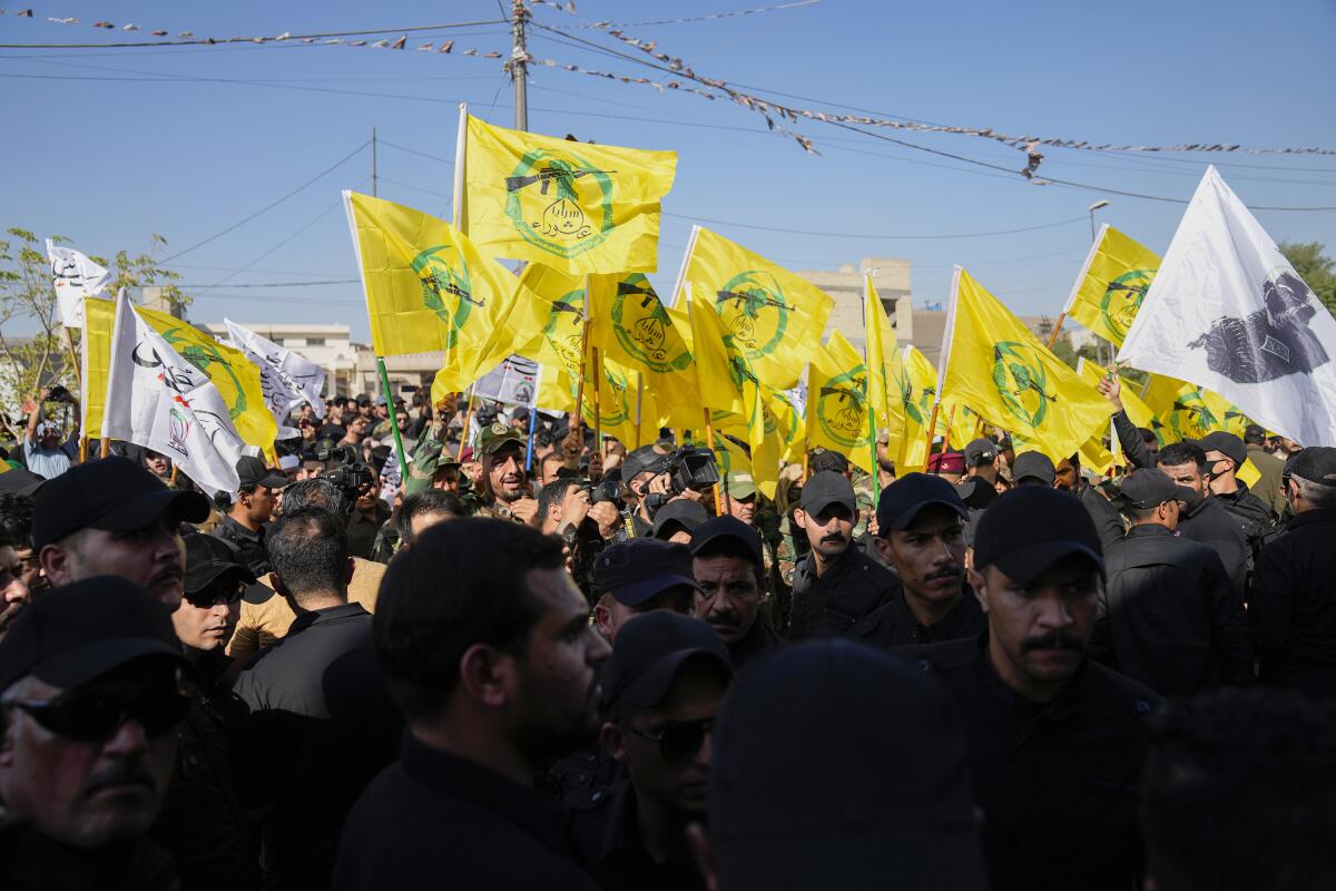 A crowd of people outdoors holding yellow flags