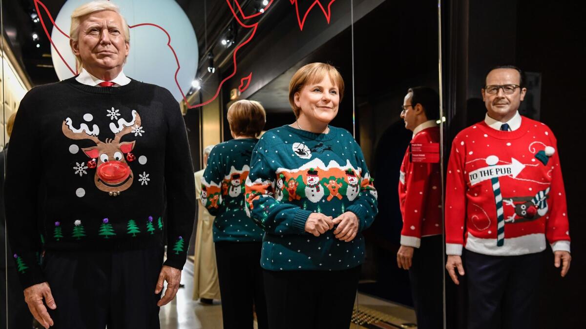 Wax figures of President Trump, German Chancellor Angela Merkel and former French President Francois Hollande have been decked out in holiday sweaters at Paris' Grevin wax museum.