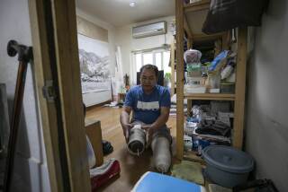 Mr. Yoon Yong-ju, representative of the neighborhood community center in Jjokbangchon in Dongja-dong, prepares to put on the prosthetic legs in his room. Jjokbangchon means a neighborhood with a high density of jjokbangs, cramped single-person occupancies that were illegally subdivided in the past. The residents of Jjokbangchon welcome the government's public housing project; however, many landlords oppose to the idea.