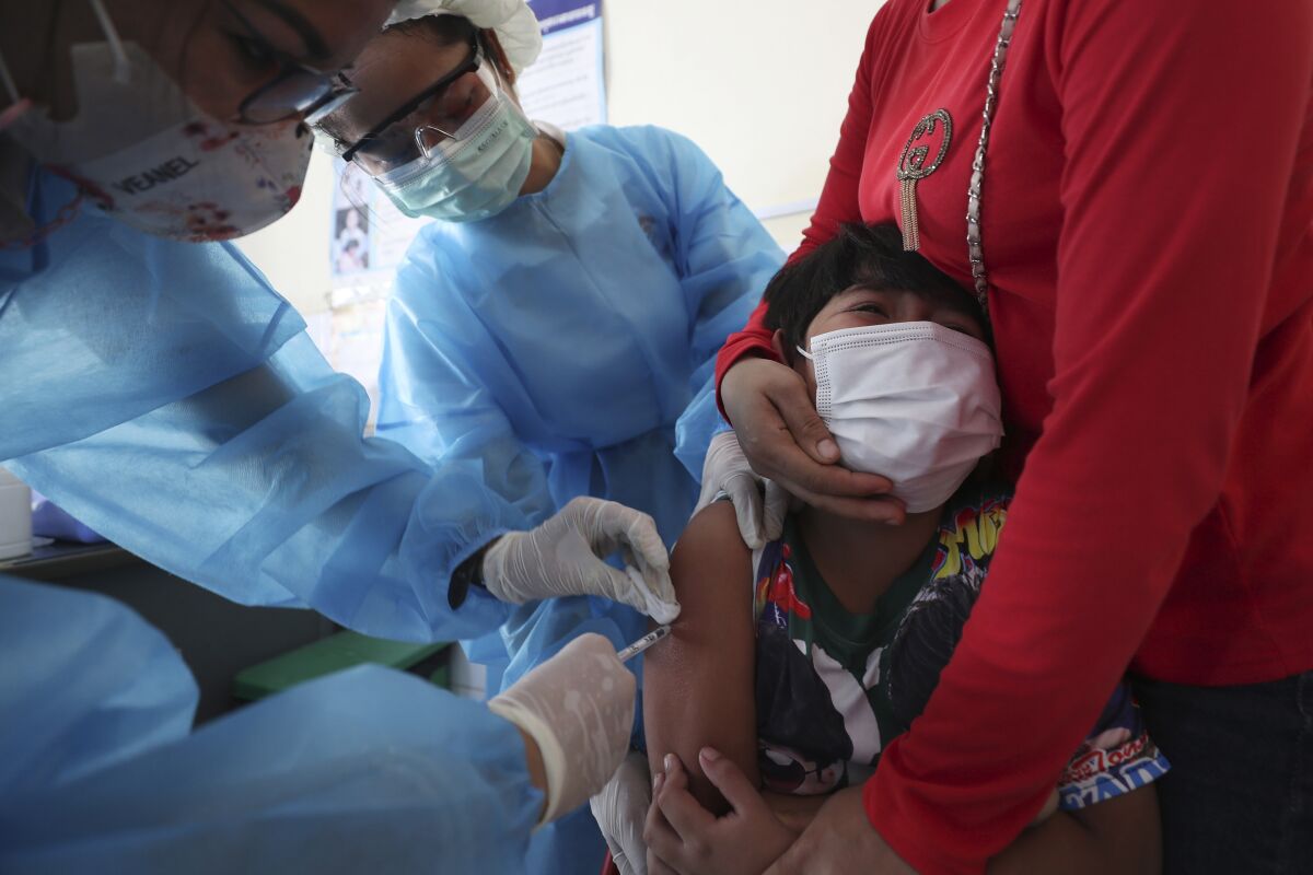 A young boy reacts as he receives a shot of the Sinovac's COVID-19 vaccine at a Samrong Krom health center outside Phnom Penh, Cambodia, Friday, Sept. 17, 2021. Prime Minister Hun Sen announced the start of a nationwide campaign to give COVID-19 vaccinations to children between the ages of 6 and 11 so they can return to school safely after a long absence due to measures taken against the spread of the coronavirus. (AP Photo/Heng Sinith)