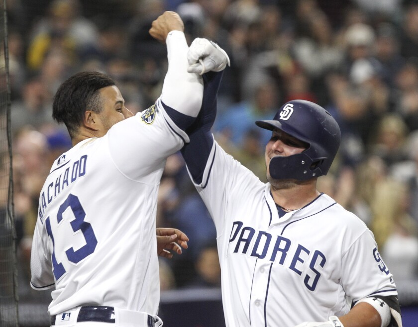 Former Padres' infielder Ty France, right, is greeted by Manny Machado after hitting a two-run home run May 7, 2019.