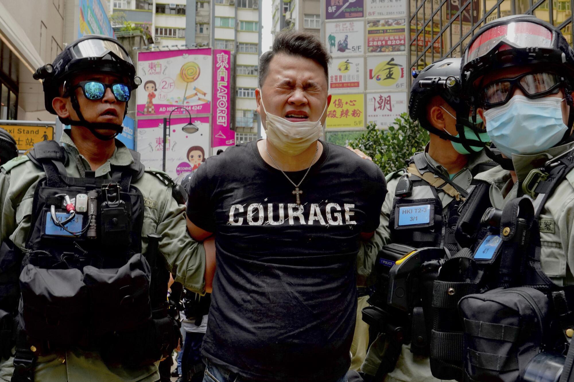 Police detain a protester after being sprayed with pepper spray during a protest in Causeway Bay 