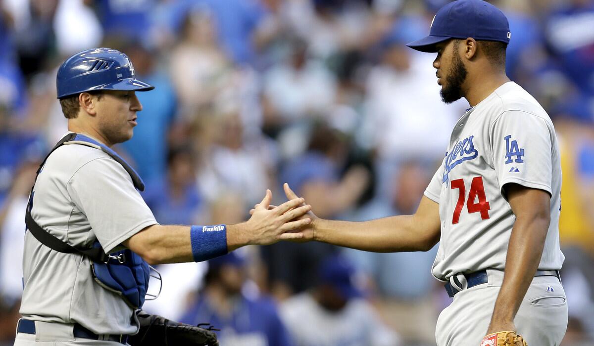 Dodgers catcher A.J. Ellis and closer Kenley Jansen celebrate after recording the final out in a 5-1 victory over the Brewers on Sunday afternoon in Milwaukee.