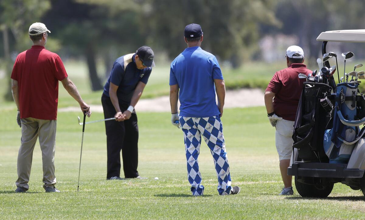 Golfers play a round at Mile Square Regional Park's Classic course on Friday. 