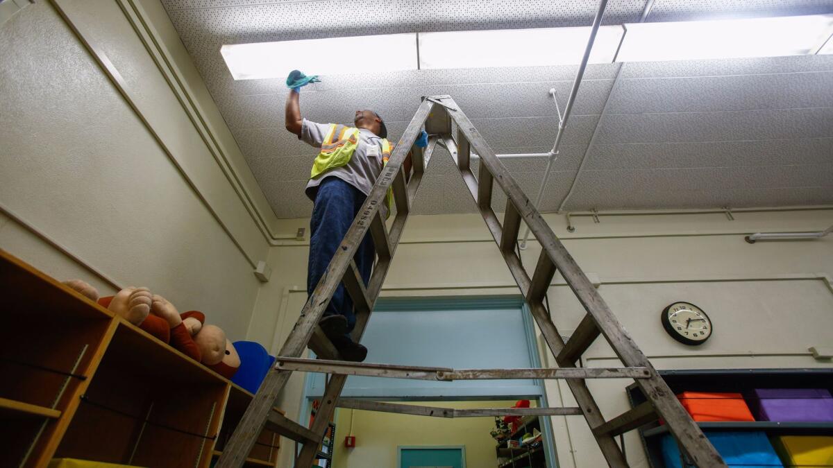 Before Los Angeles schools open for the fall, rooms at 49th Street Elementary and elsewhere must be cleaned from top to bottom, with the help of L.A. Unified Building and Grounds worker Johnny Bowie and others.
