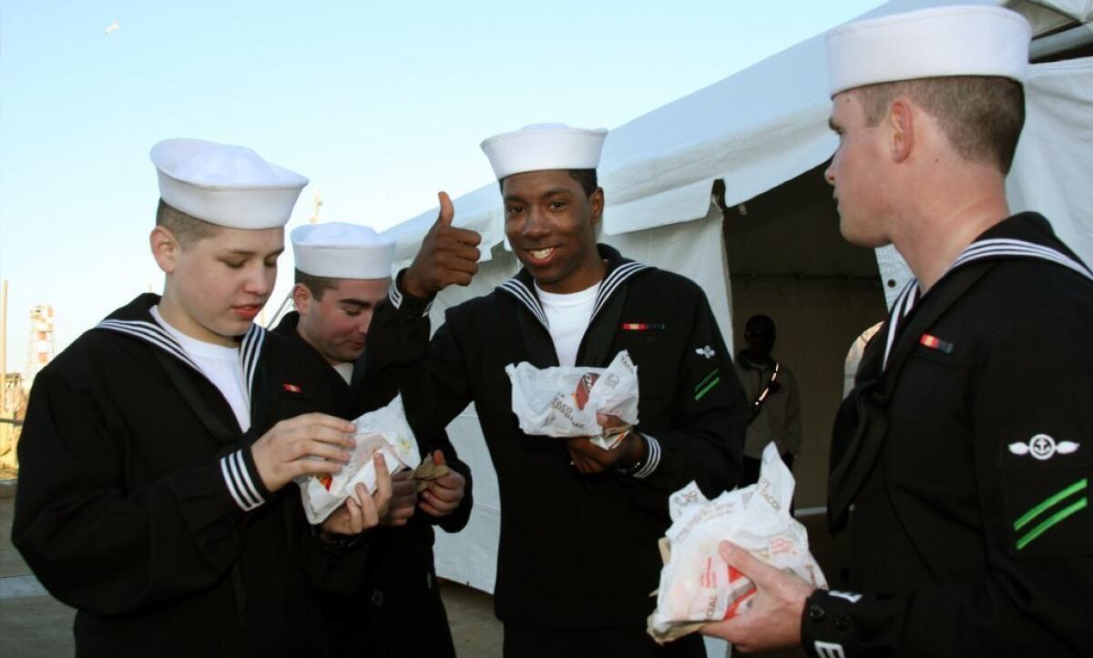Sailors returning from Middle East deployment are shown holding Doritos Locos Tacos.