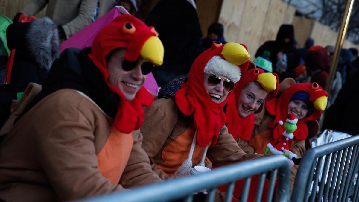 People try to stay warm before the Macy's Thanksgiving Day Parade in New York on Thursday.