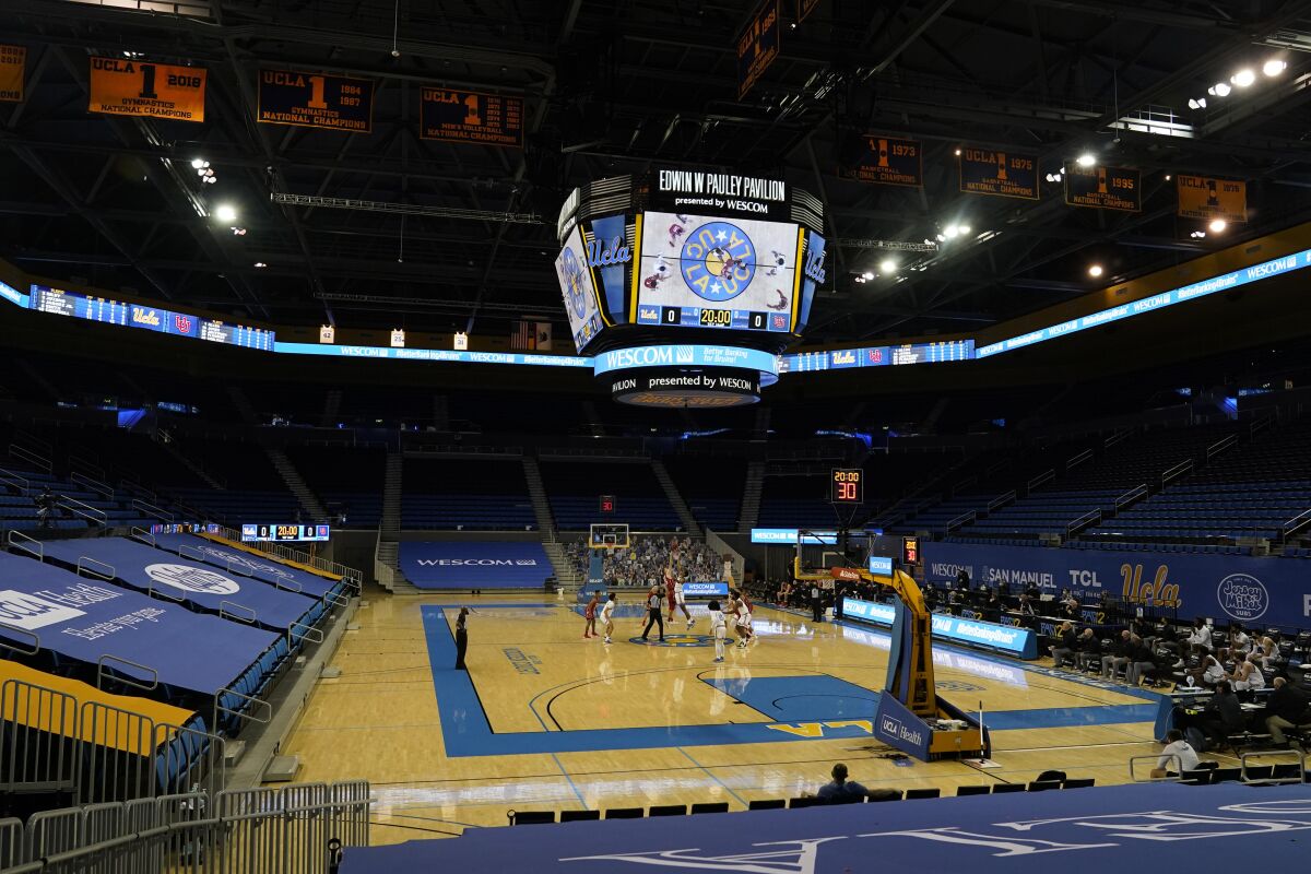 In this Dec. 31, 2020, file photo, Utah tips off against UCLA at an empty Pauley Pavilion amid the COVID-19 pandemic.