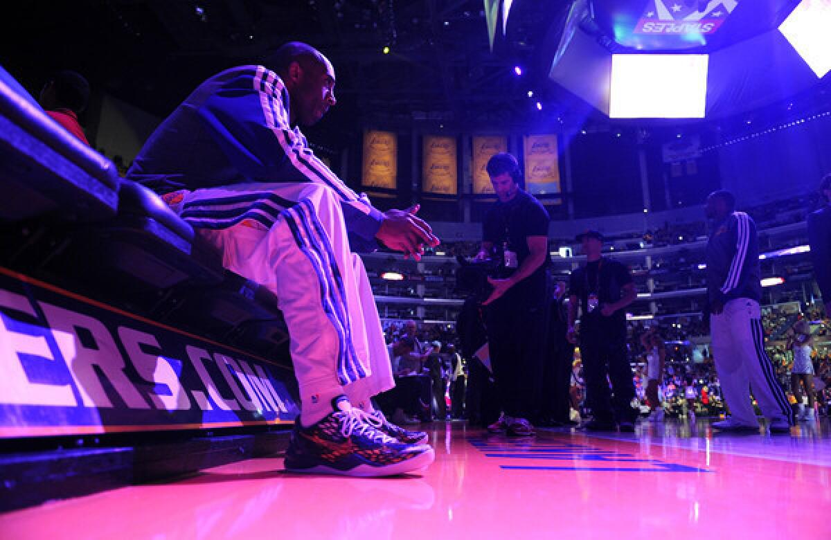 Lakers star Kobe Bryant sits on the bench before being introduced during a game against the Chicago Bulls in March. The Lakers' television contract has added value to the franchise, according to Forbes.