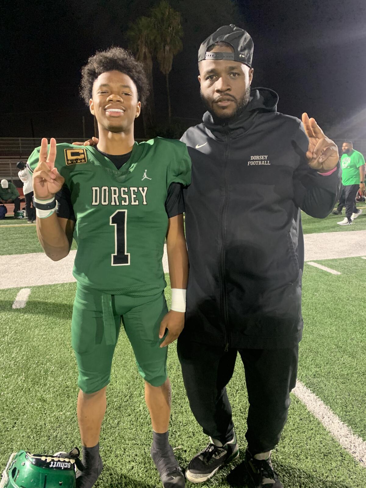 Deuce Johnson poses on the field with his father, Stafon Johnson.