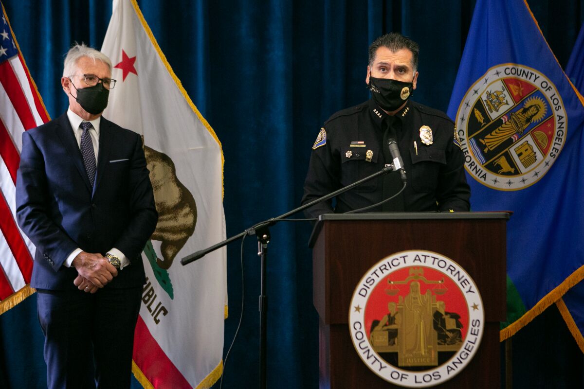 Long Beach Police Chief Robert G. Luna, wearing a mask, speaks at a news conference