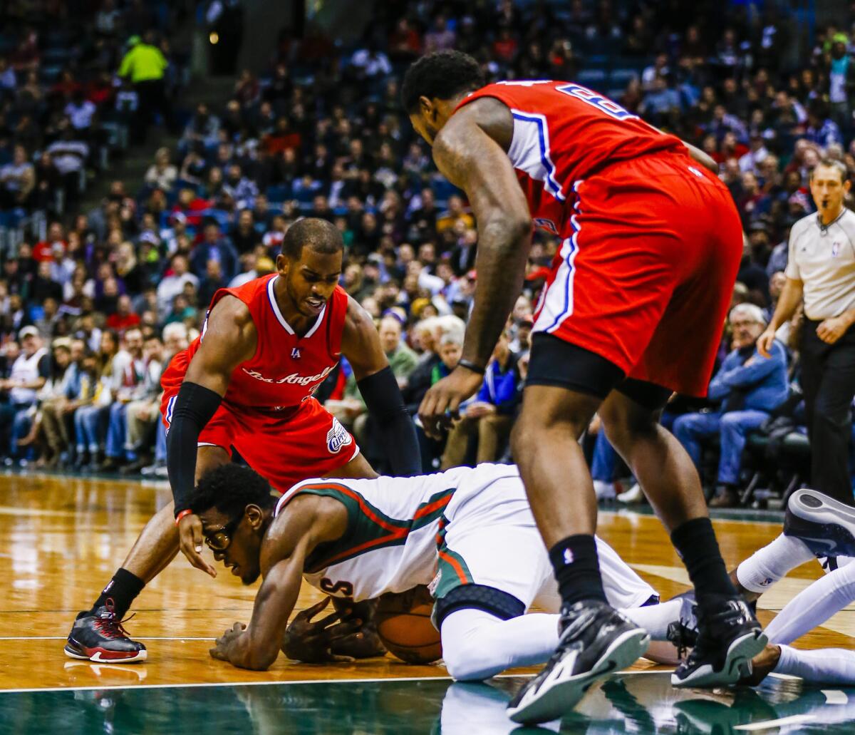 Bucks center Larry Sanders dives onto a loose ball between Clippers point guard Chris Paul and center DeAndre Jordan in the second half.