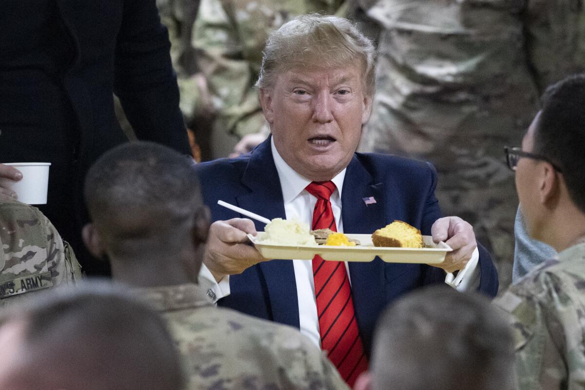 President Trump holds up a tray of Thanksgiving dinner at Bagram Air Field, Afghanistan. 