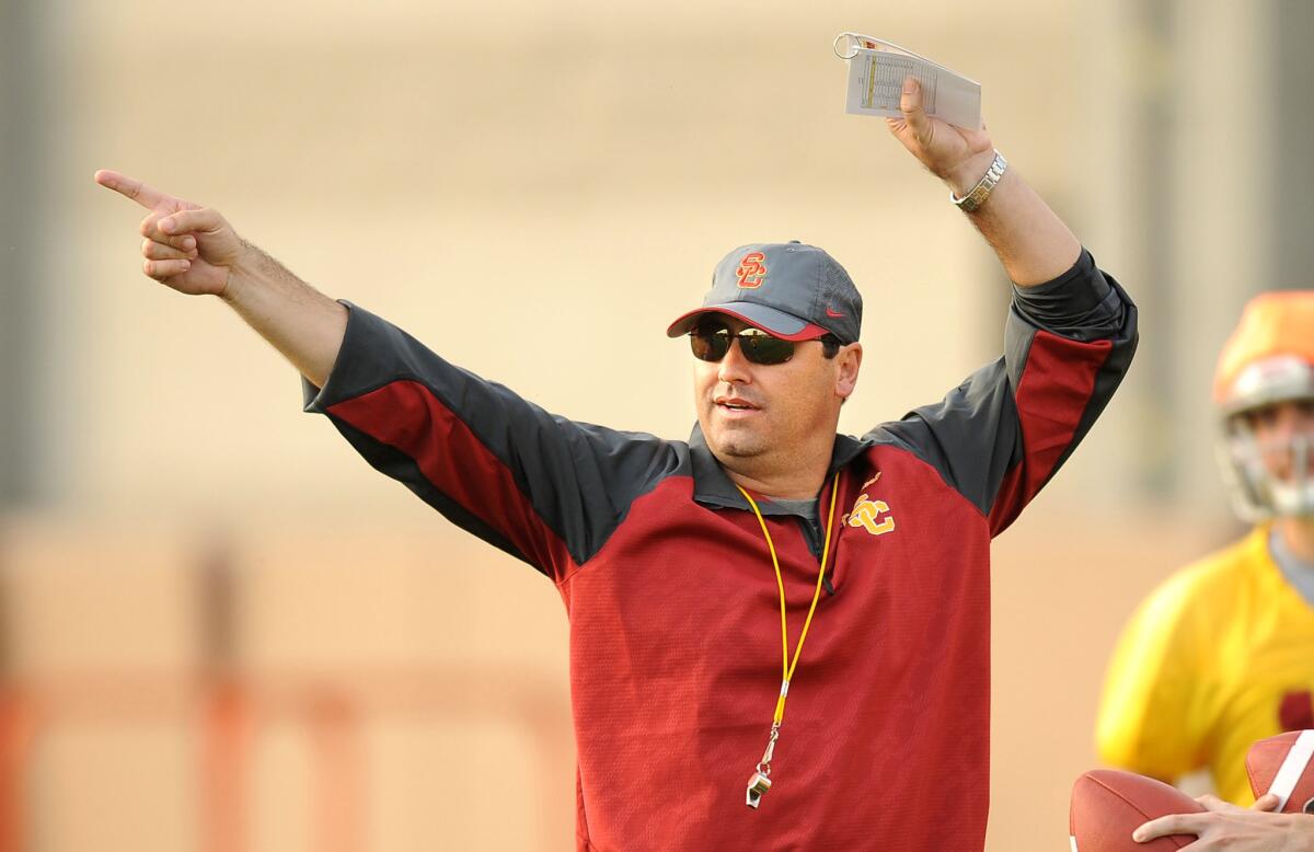 USC Coach Steve Sarkisian instructs his players during a practice in March 2014.