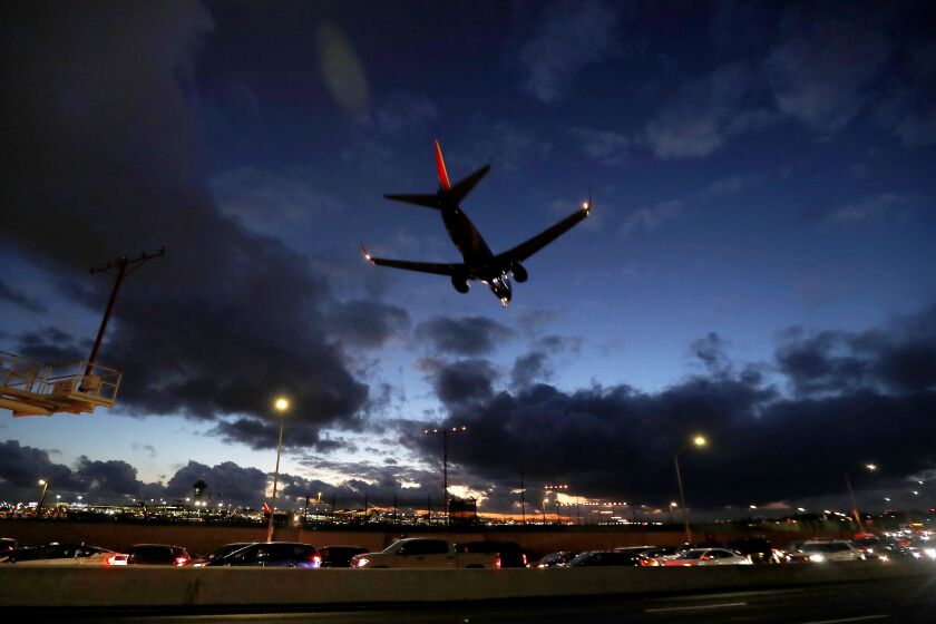 LOS ANGELES, CALIF. - NOV. 27, 2019. Motor traffic crawls along Linclon Boulevard as a plane lands at LAX under stormy skies on Wednesday, Nov. 27, 2019. Another wave of intense weather is expected on Thanksgiving Day and possibly over the weekend. Cold, rain and snow has wreaked havoc with holiday travelers on the ground and in the air. (Luis Sinco/Los Angeles Times)