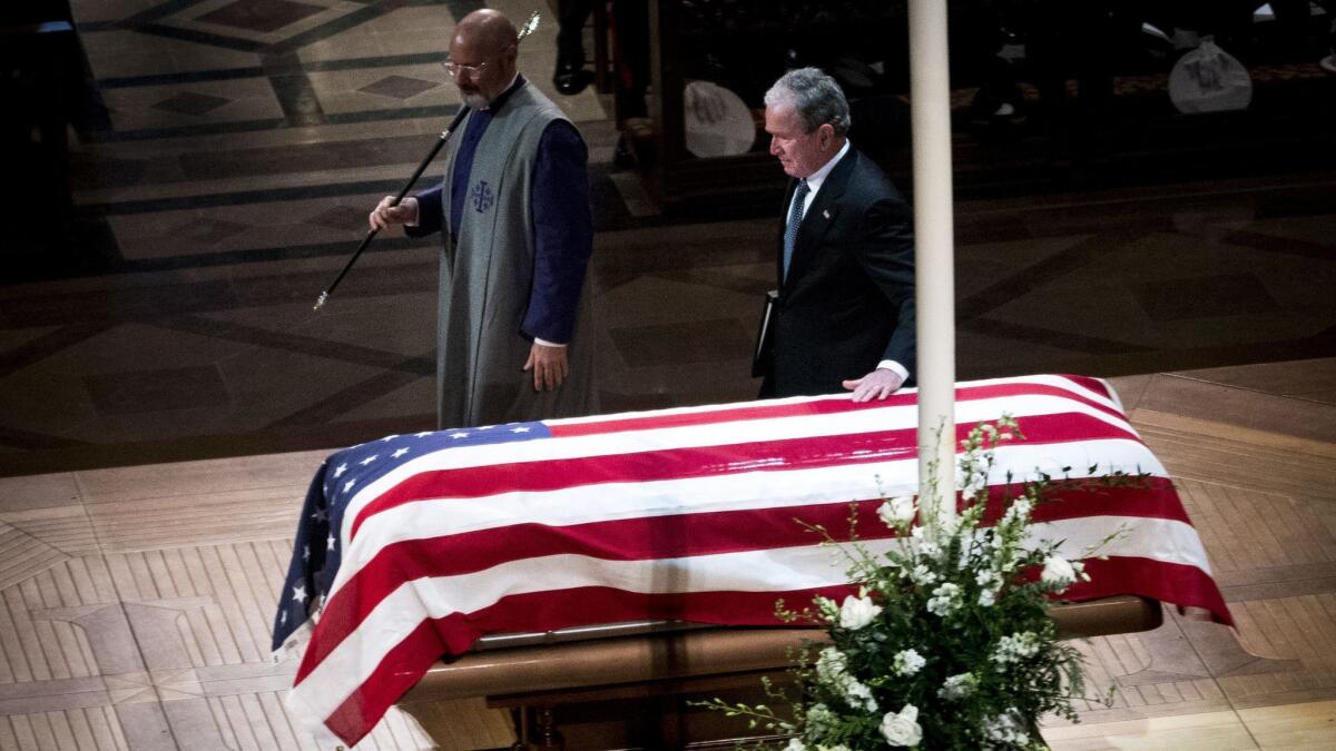 Former President George W. Bush touches the coffin as he arrives Dec. 5 to deliver the eulogy during the funeral of his father, former President George H.W. Bush, at the National Cathedral in Washington D.C.