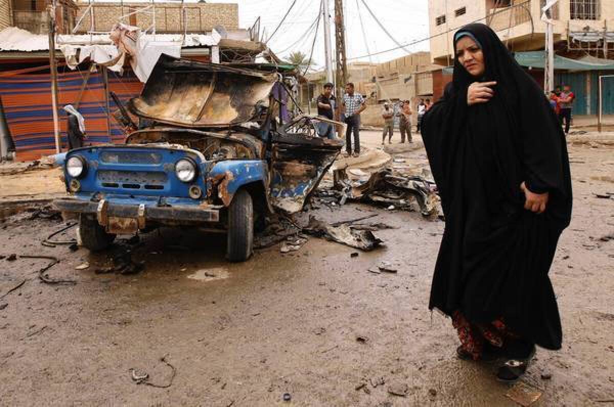 An Iraqi passes the scene of a car bombing in Kamaliya, in east Baghdad.