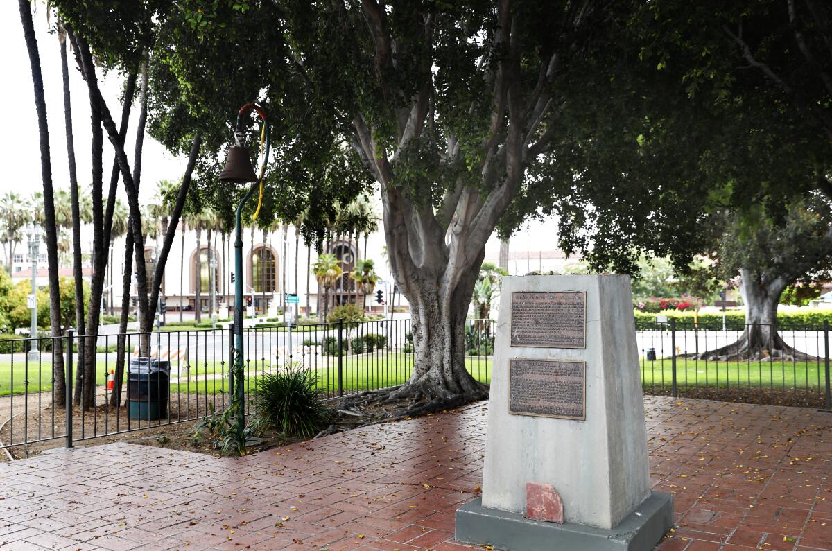 A view of an empty pedestal in Serra Park with Union Station in the far background.