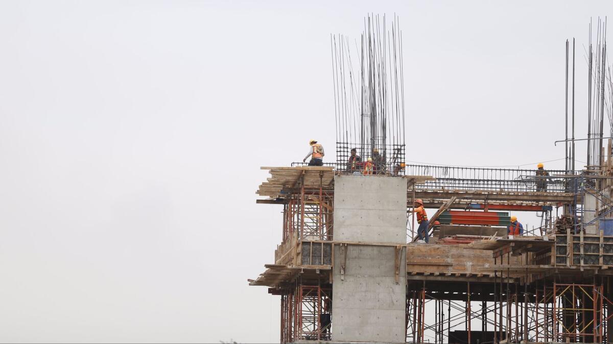 With more than 20 building projects in the works, Tijuana condo developments are changing the landscape of the city. Pictured: Construction workers working at Angular a 48-unit condo development.