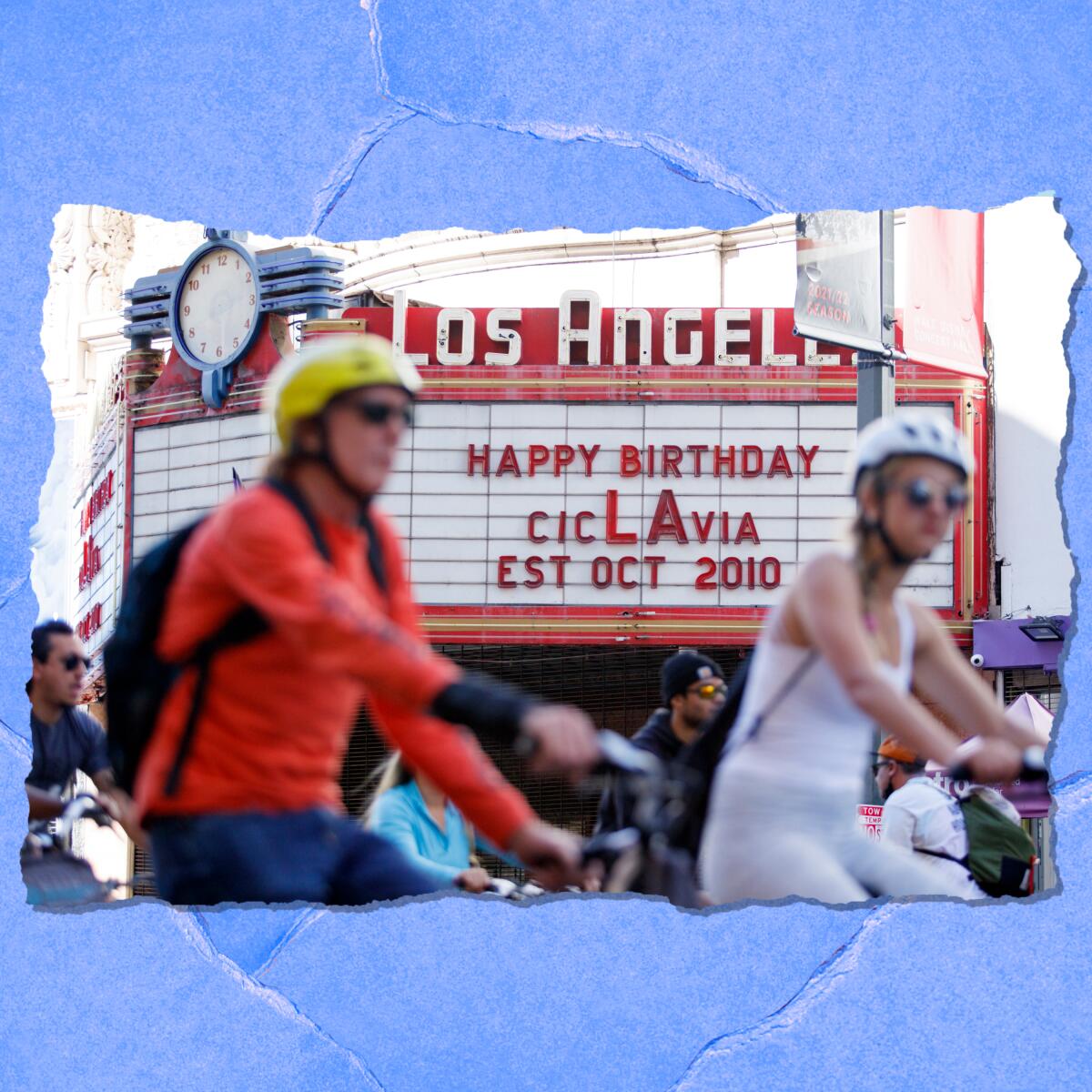 Two people on bikes with helmets pass a cinema marque that reads: "Happy birthday CicLAvia, established October 2010."
