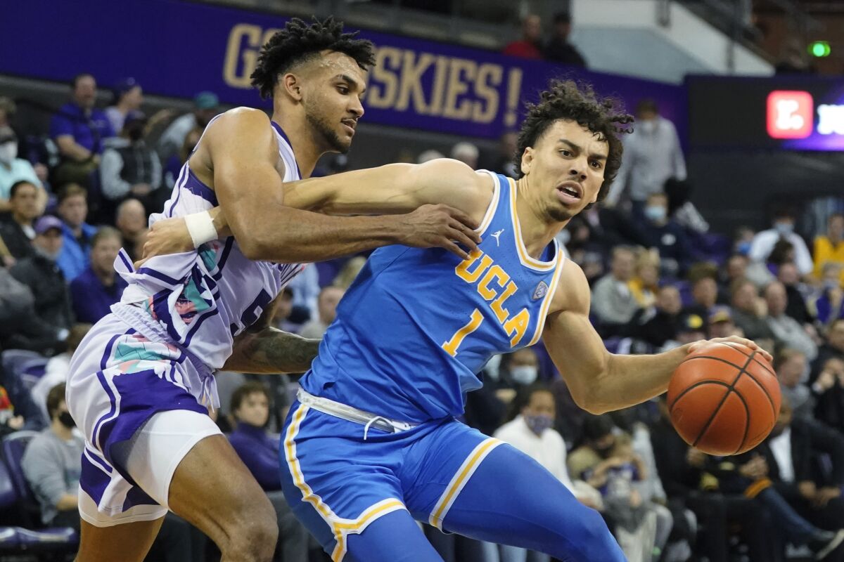 UCLA guard Jules Bernard (1) drives around Washington guard Jamal Bey, left.