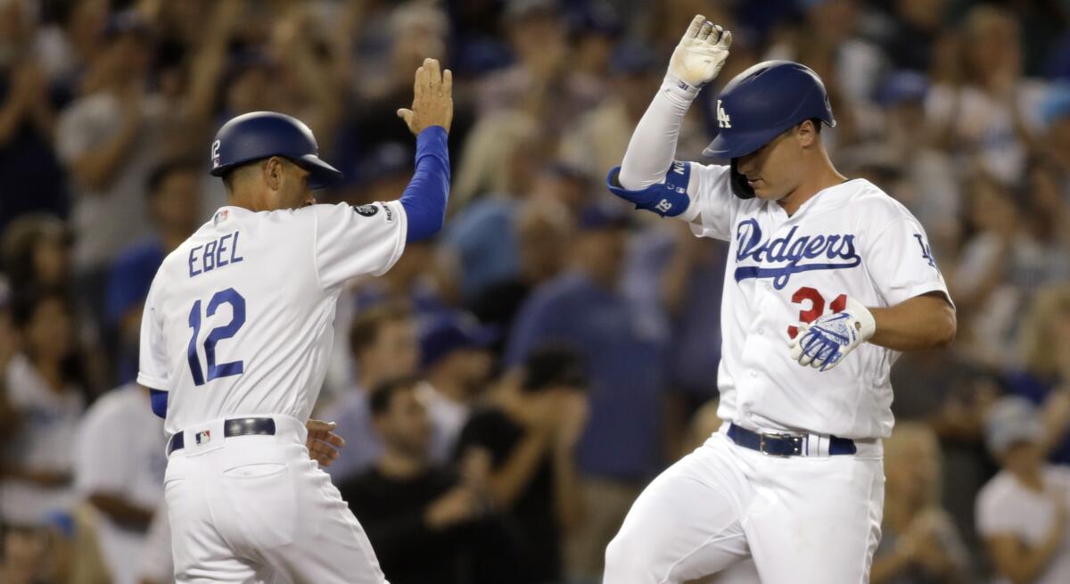 Joc Pederson, right, celebrates with Dodgers third base coach Dino Ebel after hitting a solo home run during the fourth inning against the St. Louis Cardinals.