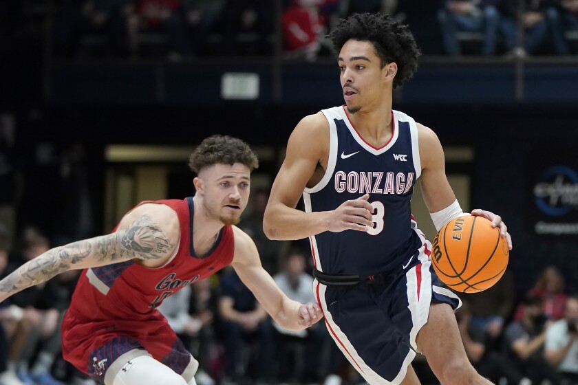 Gonzaga guard Andrew Nembhard, right, dribbles up the court past Saint Mary's guard Logan Johnson during the first half of an NCAA college basketball game in Moraga, Calif., Saturday, Feb. 26, 2022. (AP Photo/Jeff Chiu)