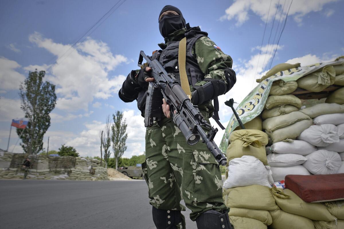 A pro-Russia militant stands at a checkpoint in the outskirts of Donetsk, Ukraine. Ukrainian President Petro Poroshenko announced a unilateral ceasefire as an incentive for the militant separatists to put down their weapons.