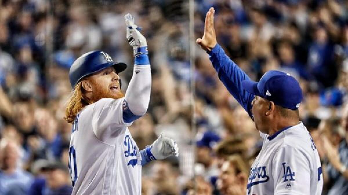 Dodgers third baseman Justin Turner, left, high-fives manager Dave Roberts after his first-inning home run in Game 1 of the National League Division Series.