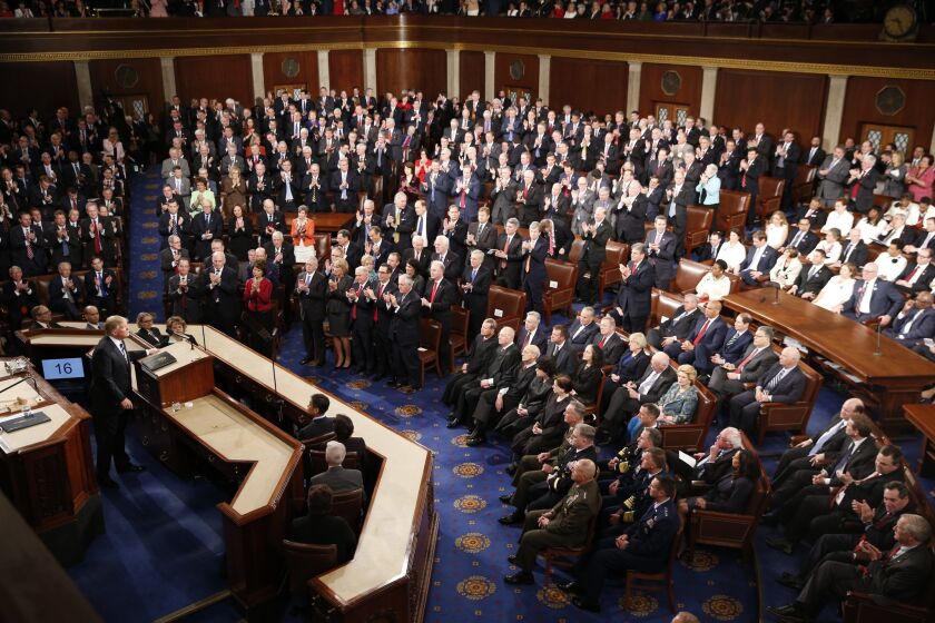 Republican members of Congress stand and applaud during the president's speech.