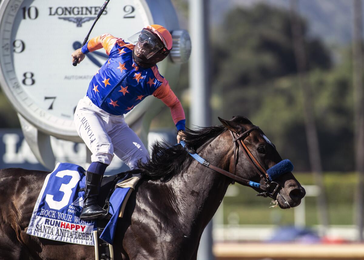 Jockey Umberto Rispoli celebrates with a fist pump after guiding Rock Your World to a win in the Santa Anita Derby