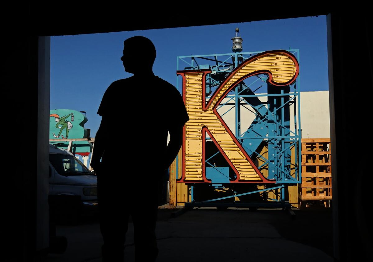 silhouette of a man with a neon K in the background