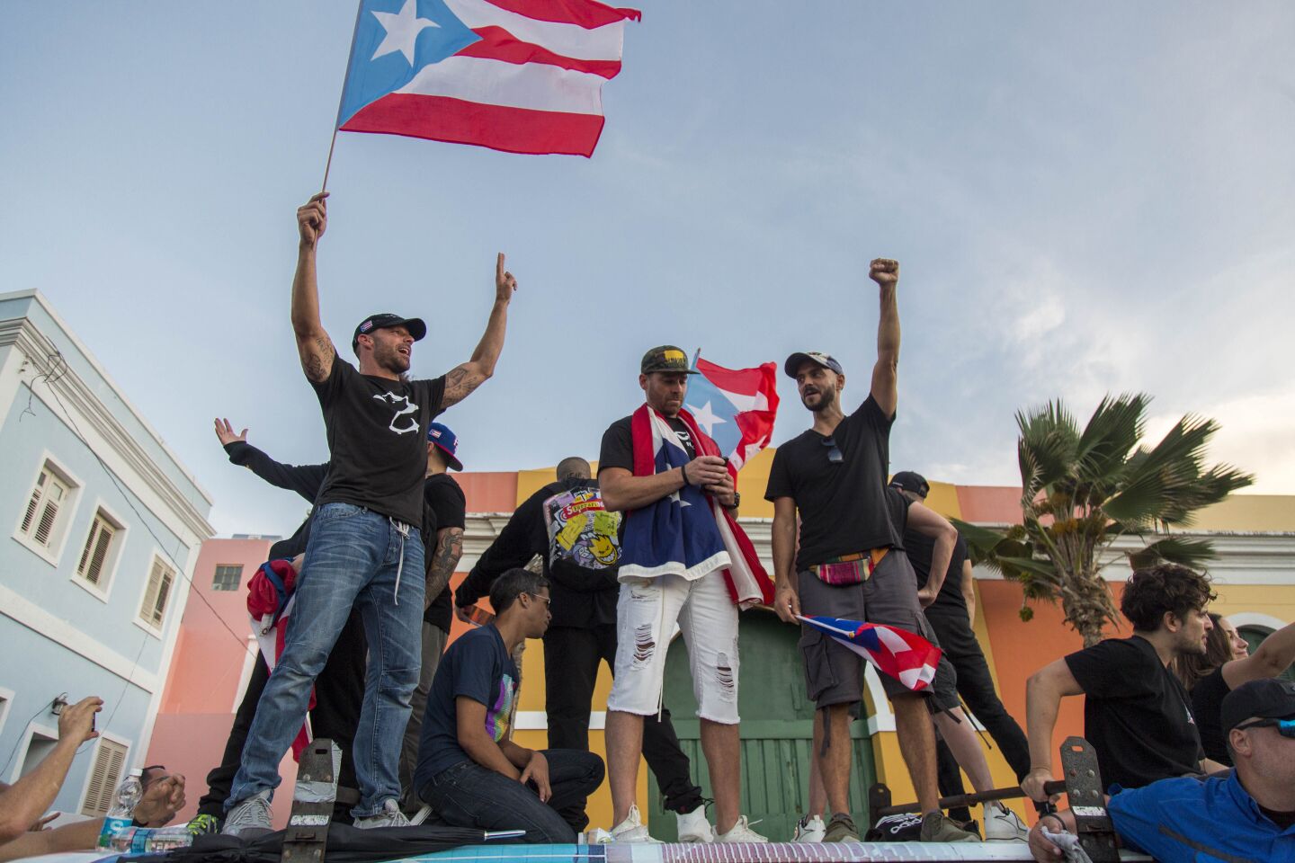 Singer Ricky Martin, left, waves the Puerto Rican flag during a protest against Gov. Ricardo Rosello in San Juan.