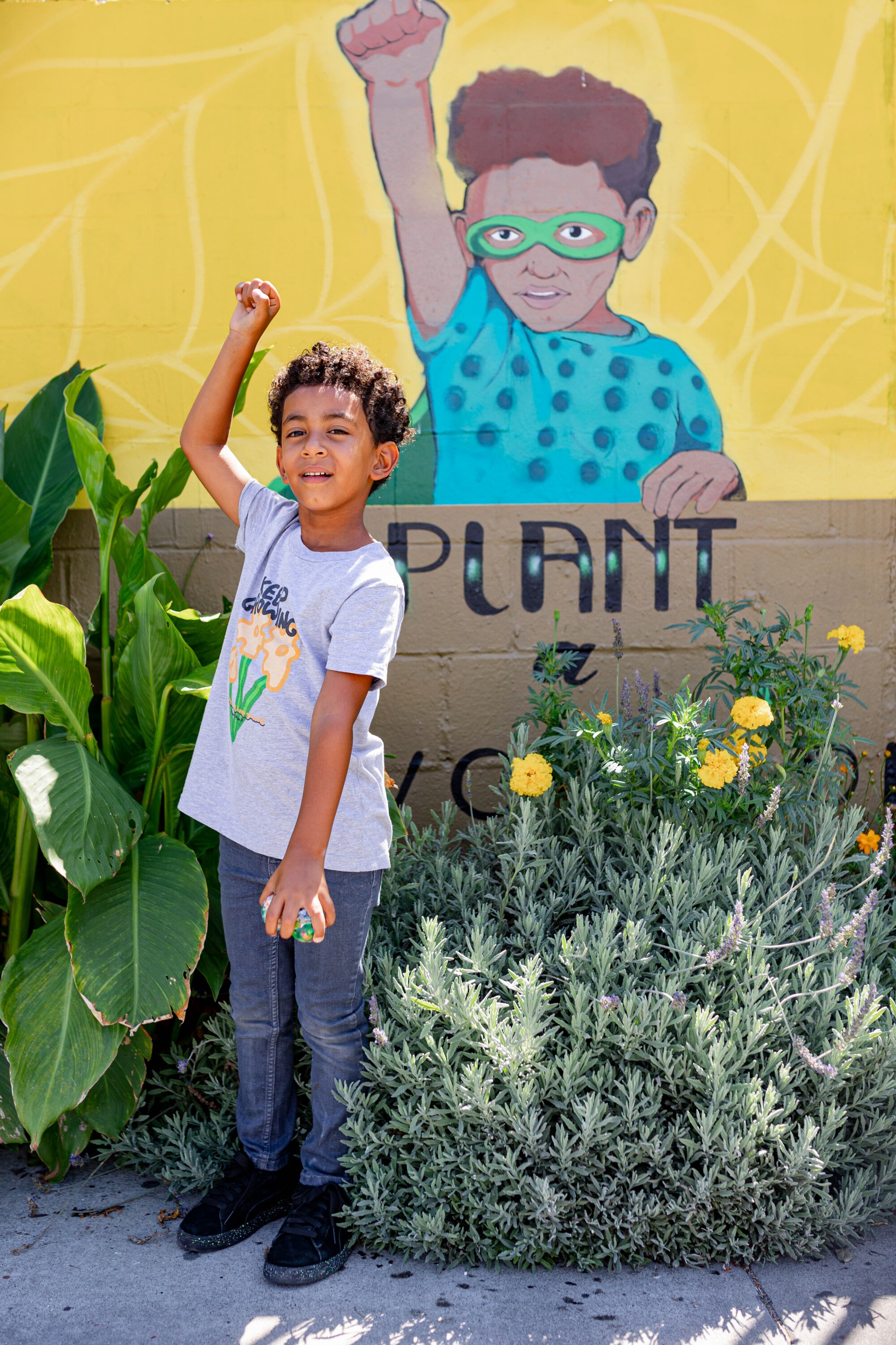 Alem Adis, 5, stands in front of a mural of him.