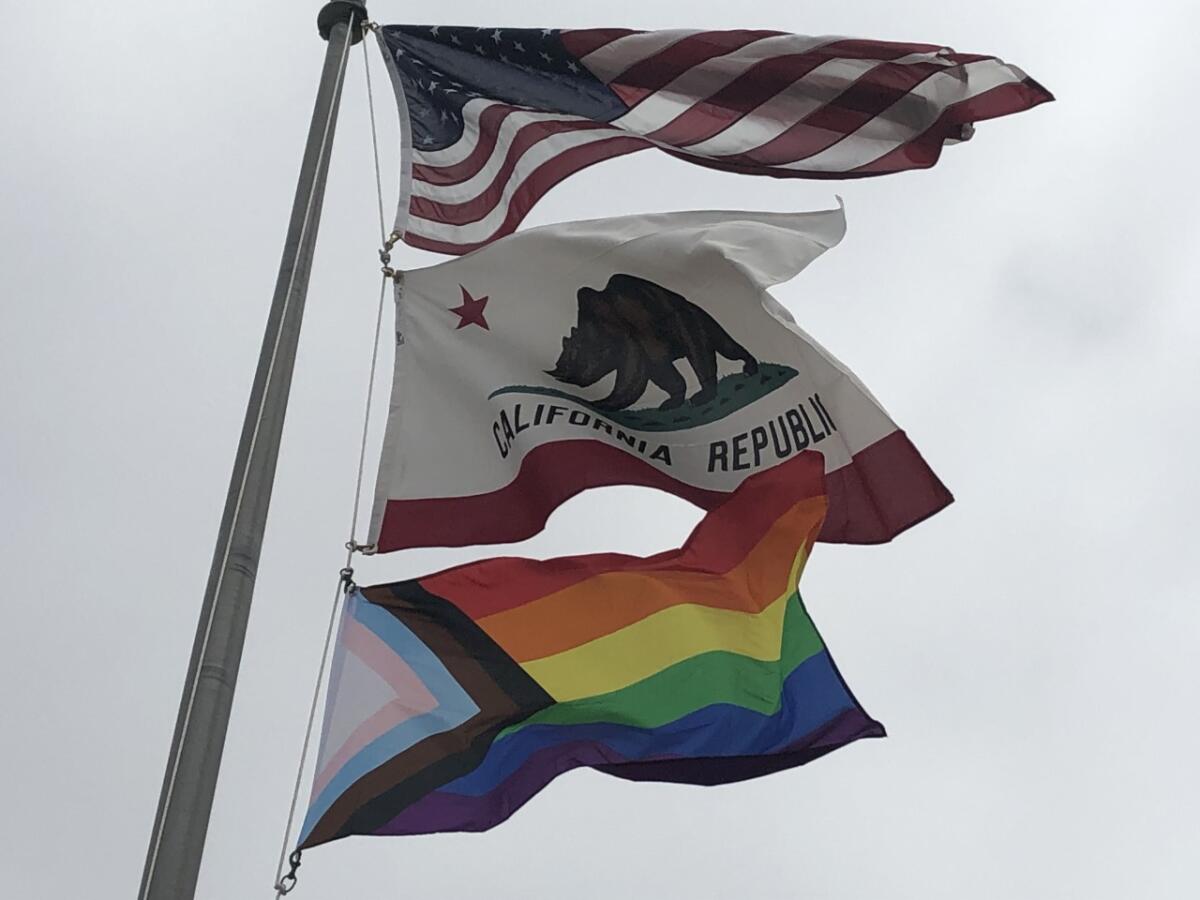 The Progressive Pride Flag flying below the American and California flags.