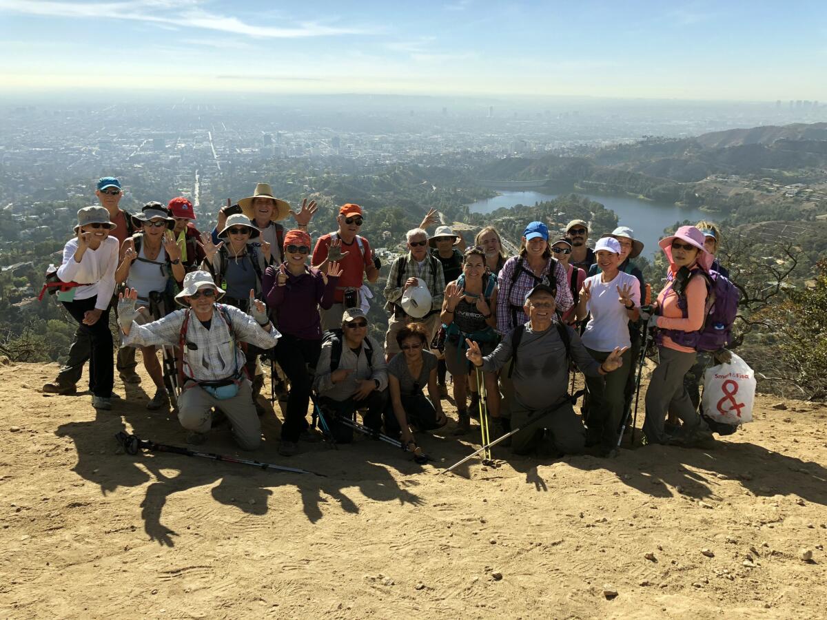 Sierra Club takes hikers to trails near and far. Here a group poses atop Mt. Lee in Griffith Park where the Hollywood sign is located.