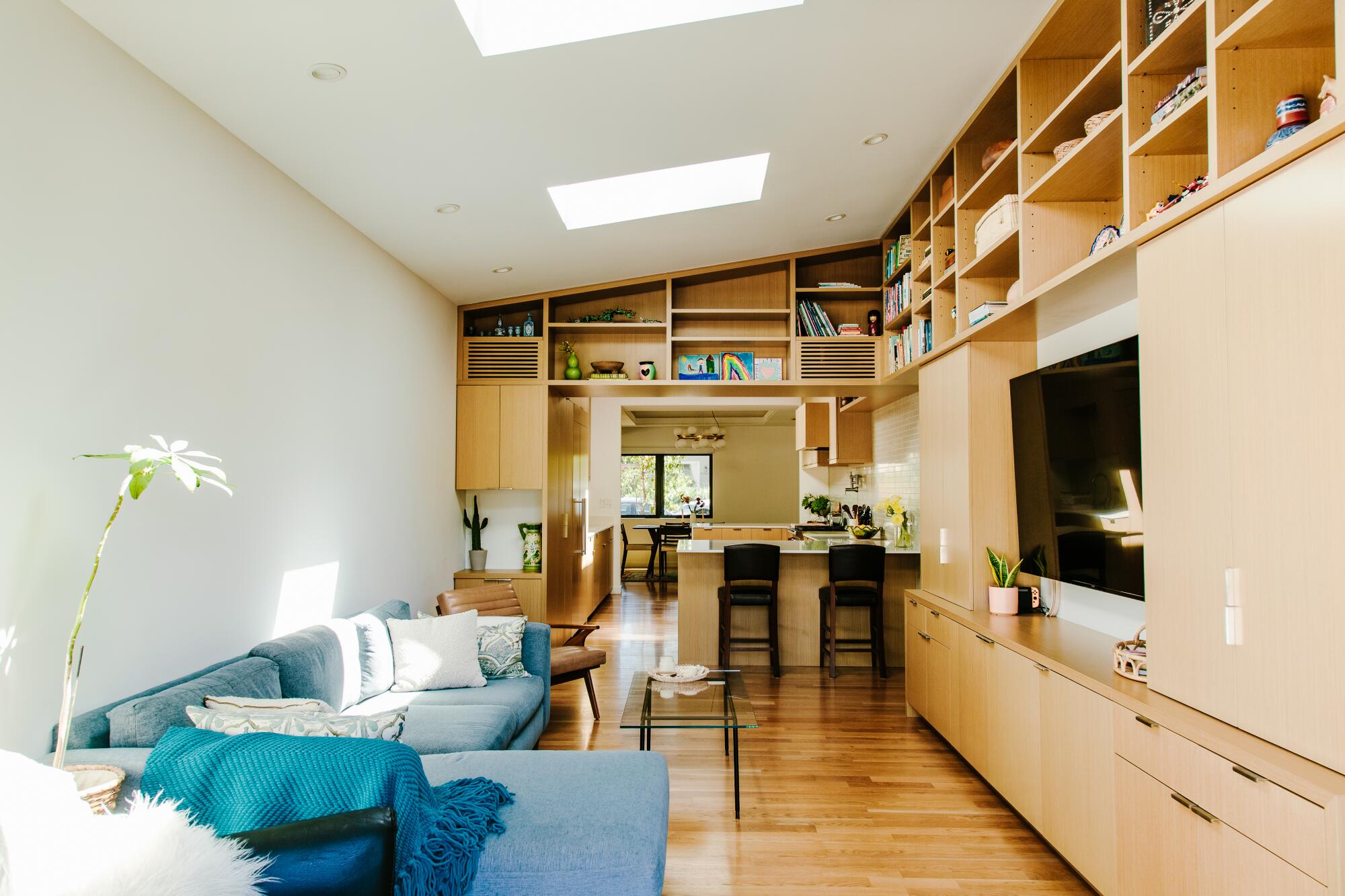 A blue couch facing a wall unit inside a family room 