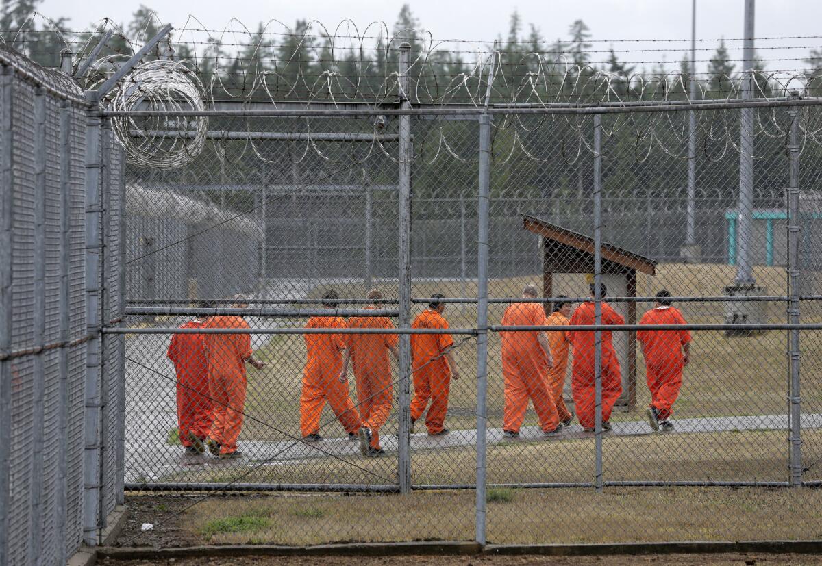 Prisoners walk toward an exercise yard at the Washington Corrections Center, in Shelton, Wash.