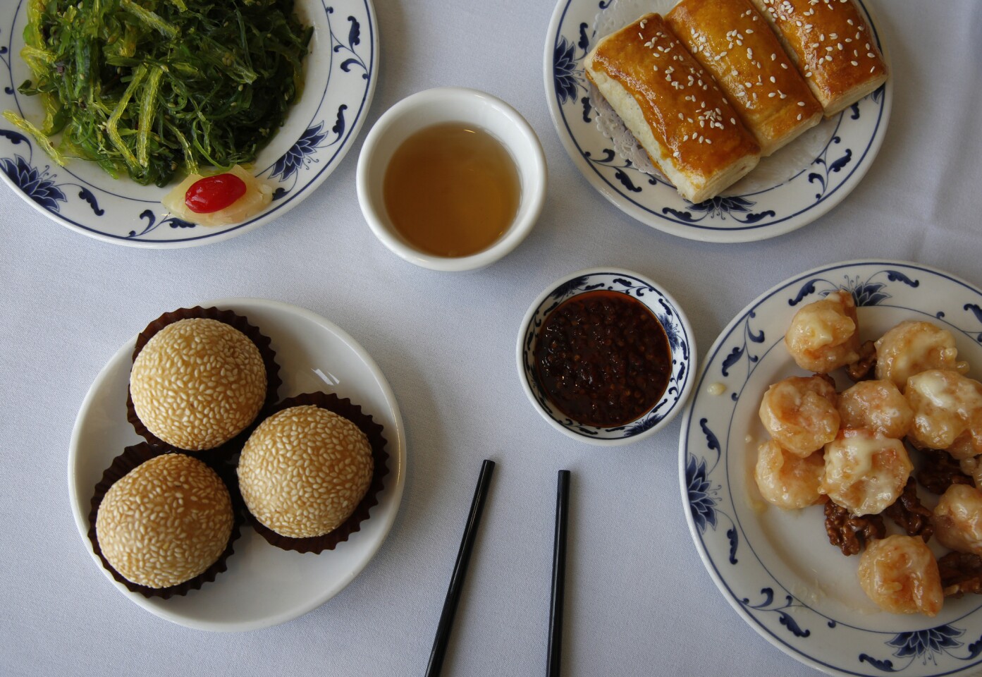 Clockwise, from top left: Seaweed salad, honey barbecue pork crispy pie, sauteed shrimp with honey walnut and sesame balls filled with red bean.