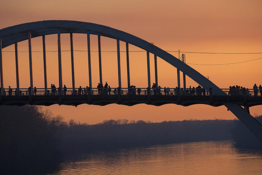 SELMA, AL - MARCH 7, 2015- People walk and stop along the Edmund Pettus Bridge at dusk March 7, 2015 in Selma. (Brian van der Brug / Los Angeles Times)