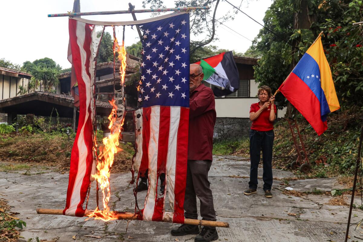 A man burns a United States flag during a rally